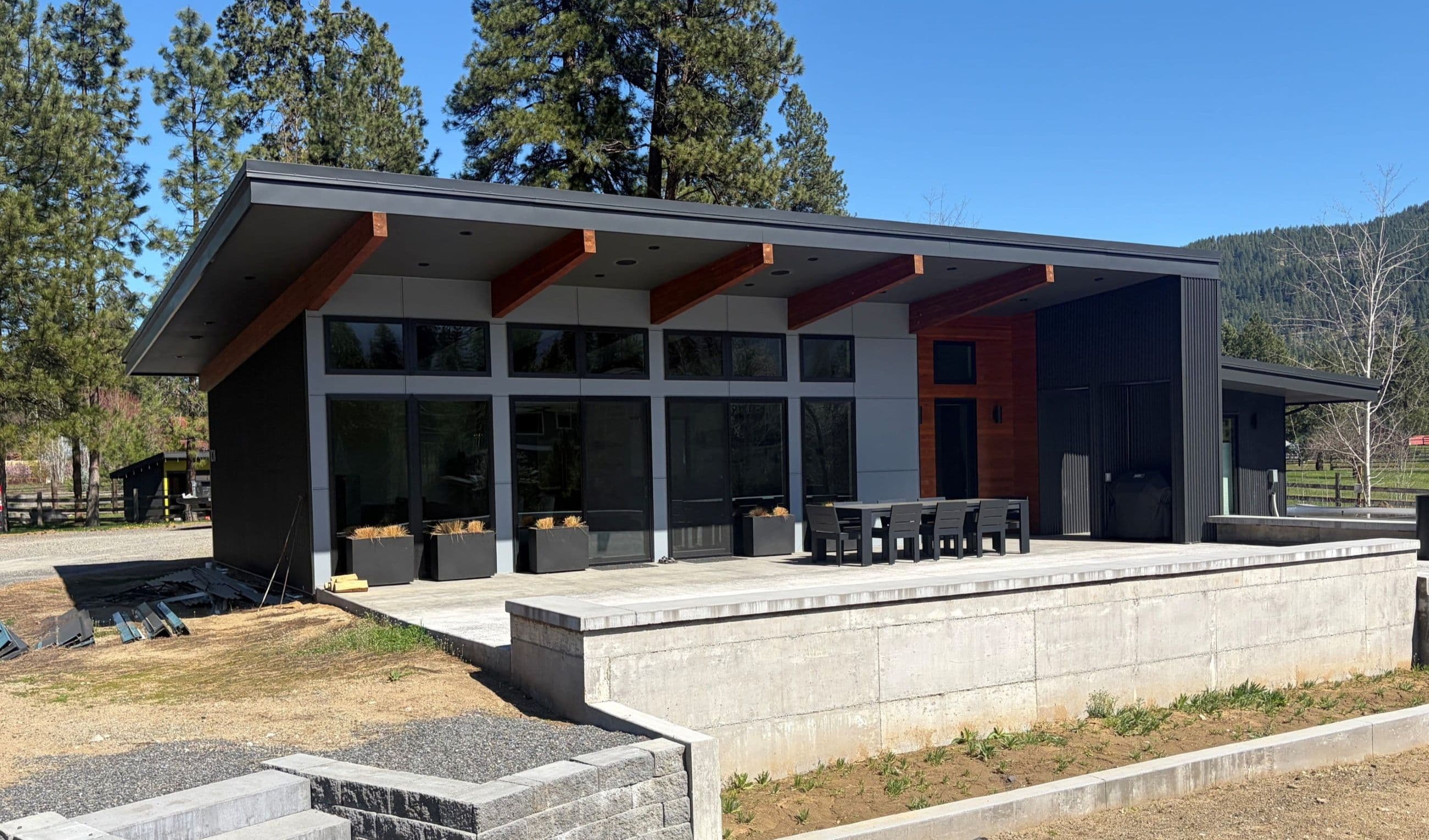 Exterior of modern one story home with expansive windows and large outdoor patio
